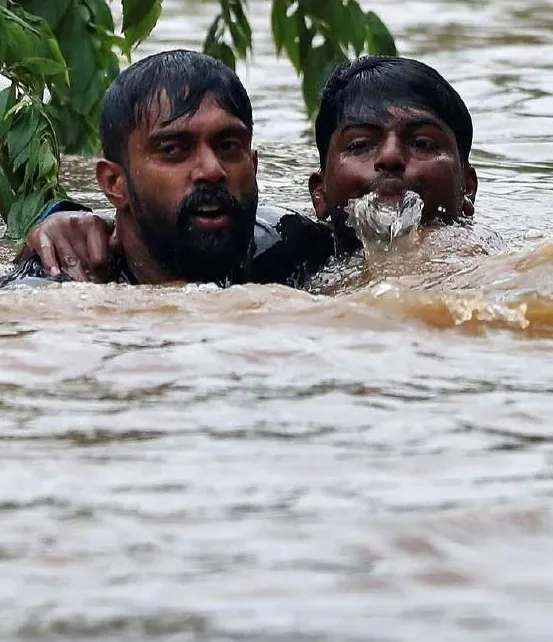 Rescuers wading through floodwater